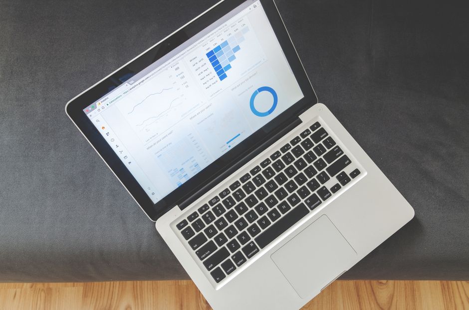 Marketer comparing Meta Ads and Google Ads performance on a laptop dashboard
