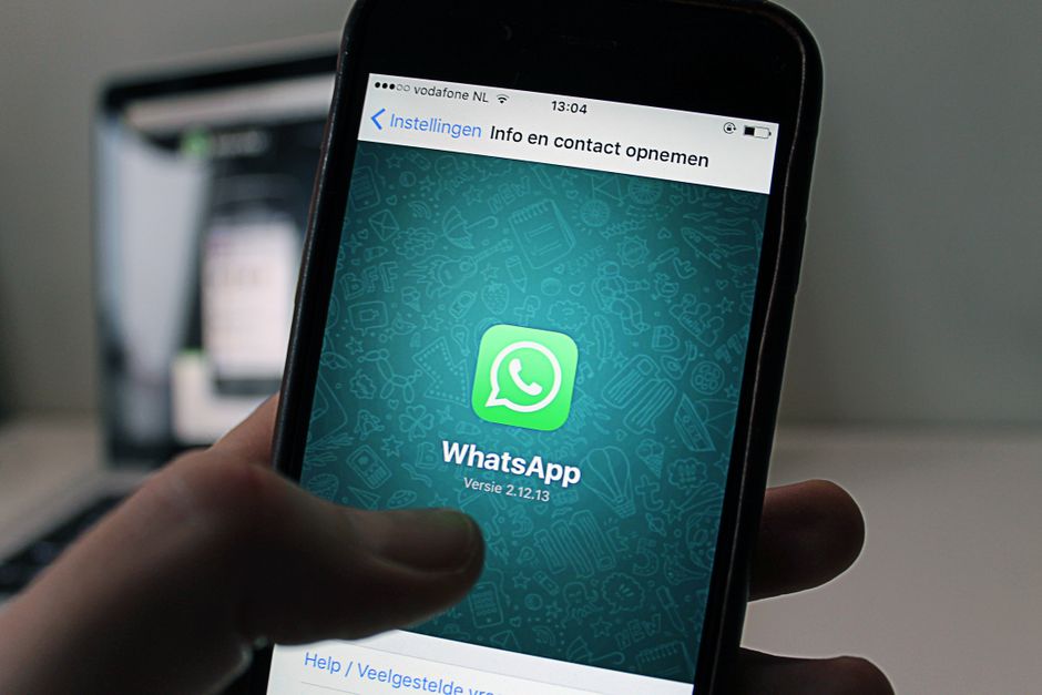 A person using WhatsApp on a smartphone to message a business